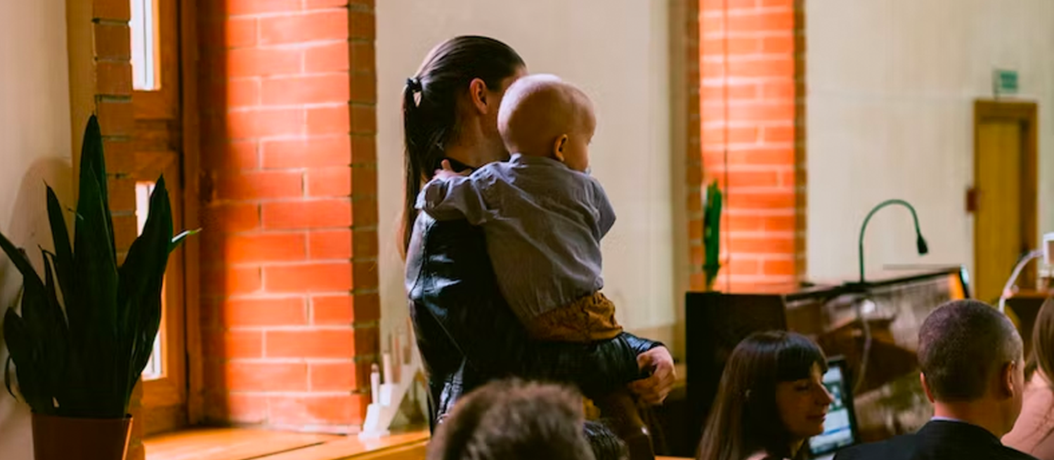 Parent carrying child in church service